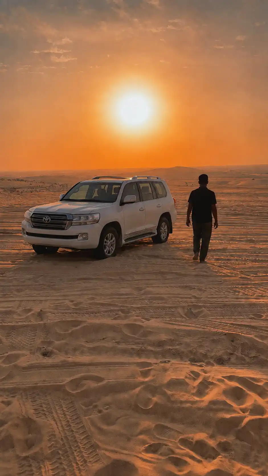 White Land Cruiser and traveler at sunset in the Qatar desert